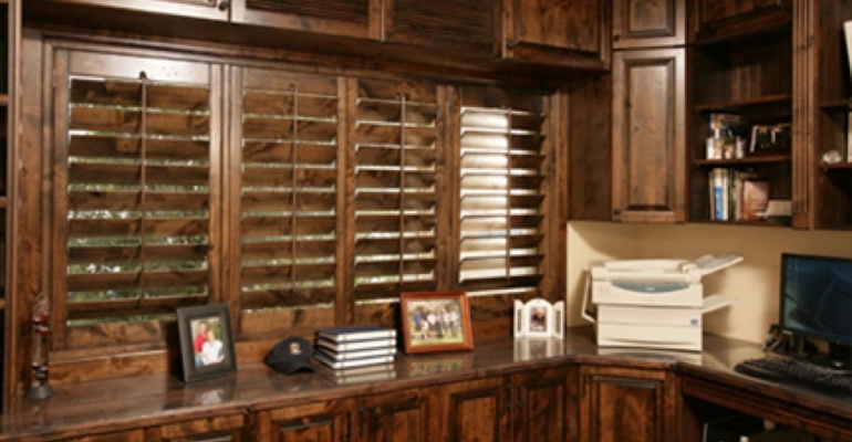 Wood shutters work well when the stain is the same as your cabinets, trim or flooring. Wood shutters in home office.